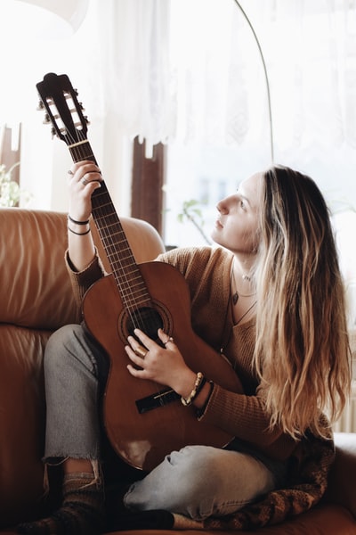 房间里窗户边弹古典吉他的女人